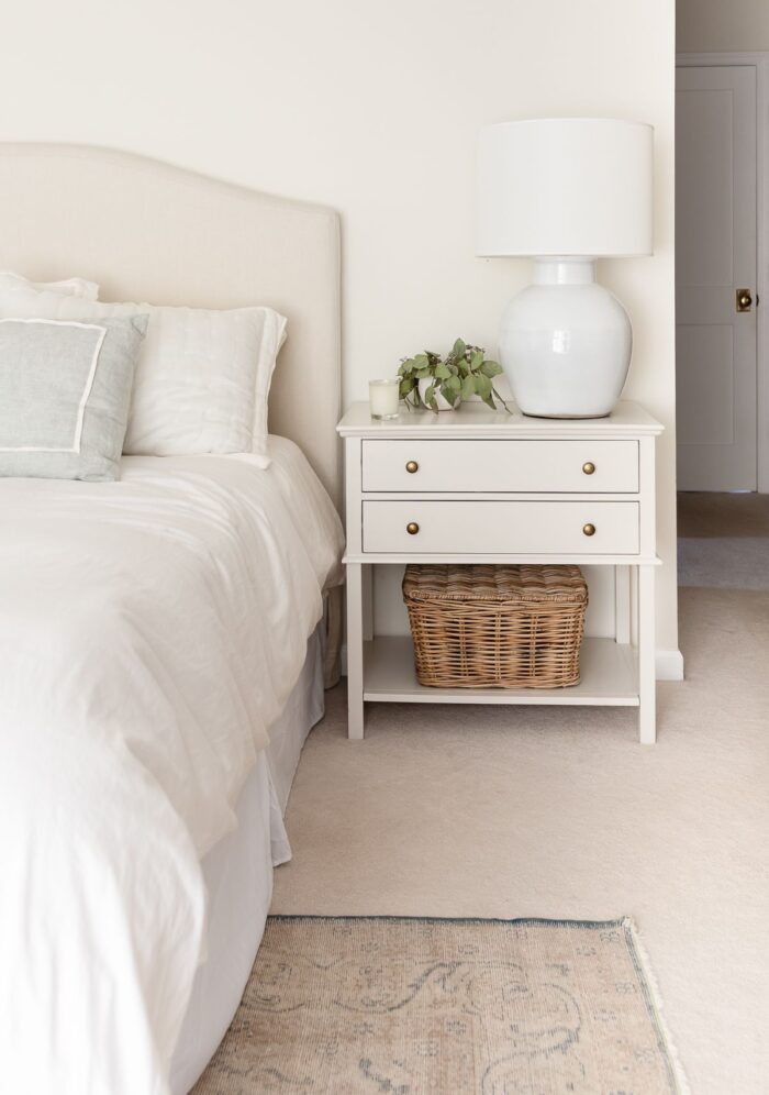 奶油卧室的床头柜，涂上淡橡树本杰明·摩尔油漆颜色。