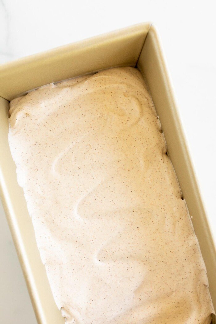 大理石表面上装满肉桂冰淇淋的金面包盘GydF4y2Ba