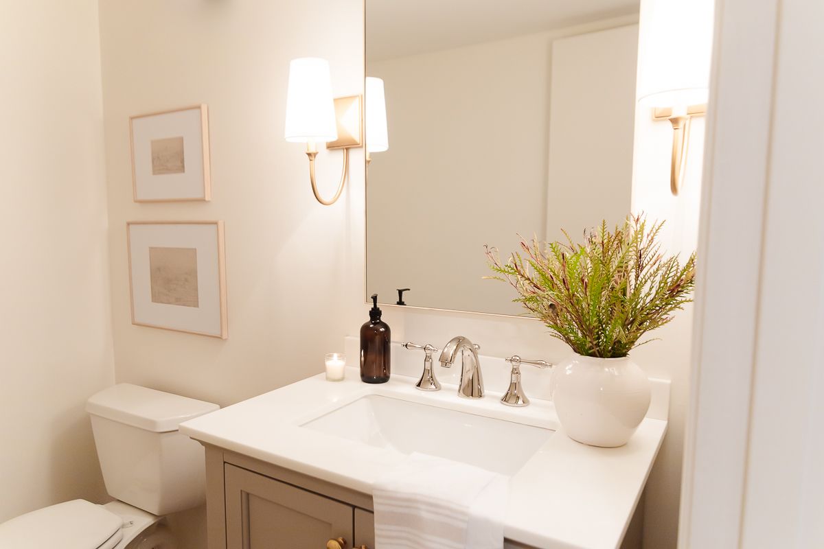 地下室的一间带有金色壁灯和灰色洗手盆的浴室