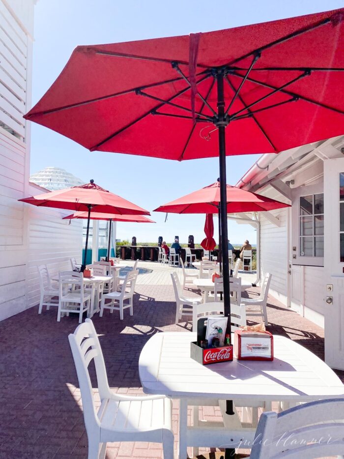 有白色桌子和红色雨伞的户外餐厅露台