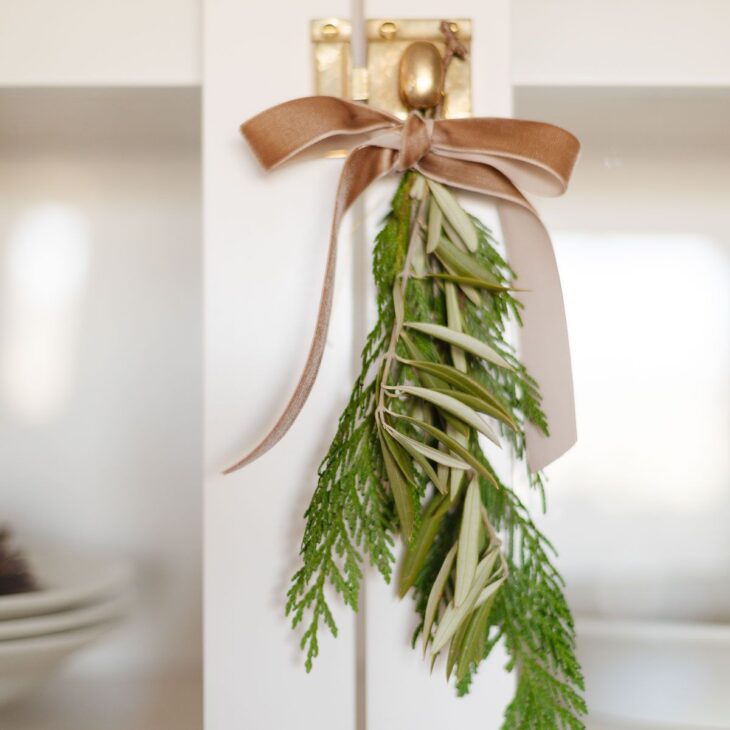 绿色植物用丝绒丝带系在一个黄铜橱柜把手上