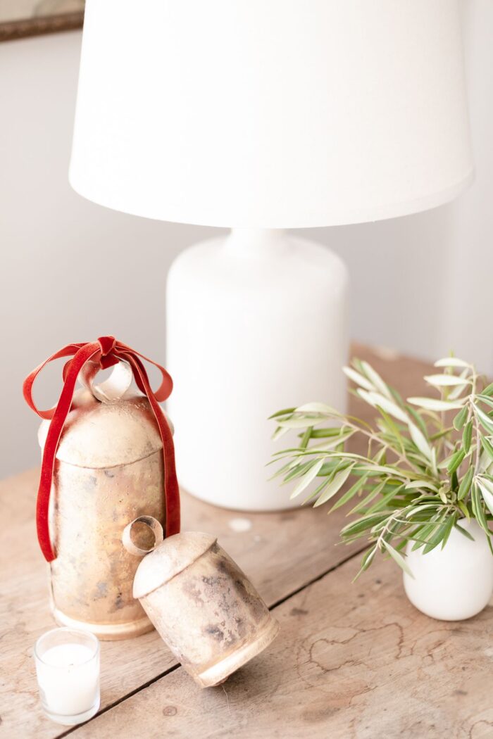 铜铃和一盏白色的灯放在一张质朴的木桌上