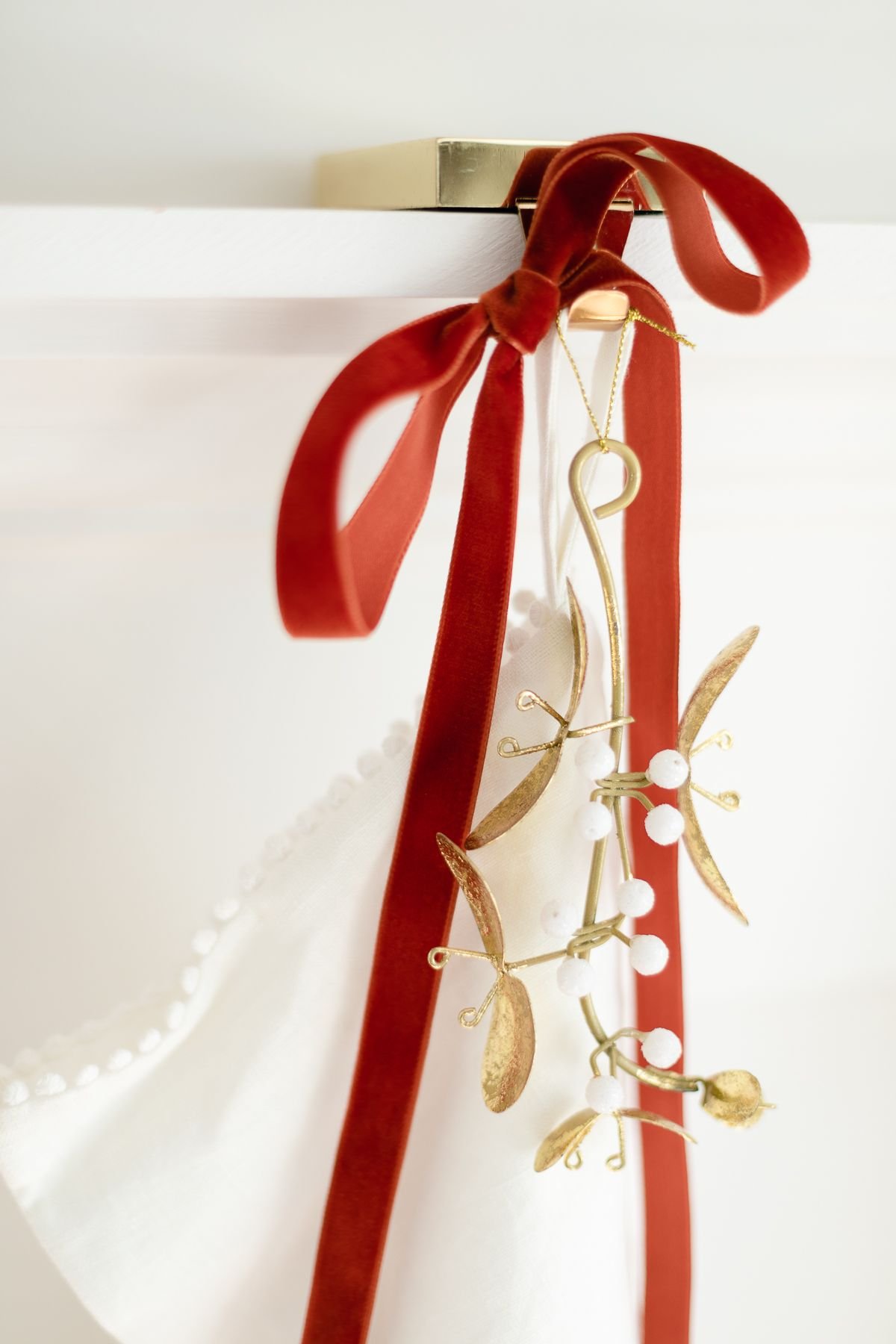 传统的圣诞装饰是丝绒丝带和白色长袜上的金色槲寄生