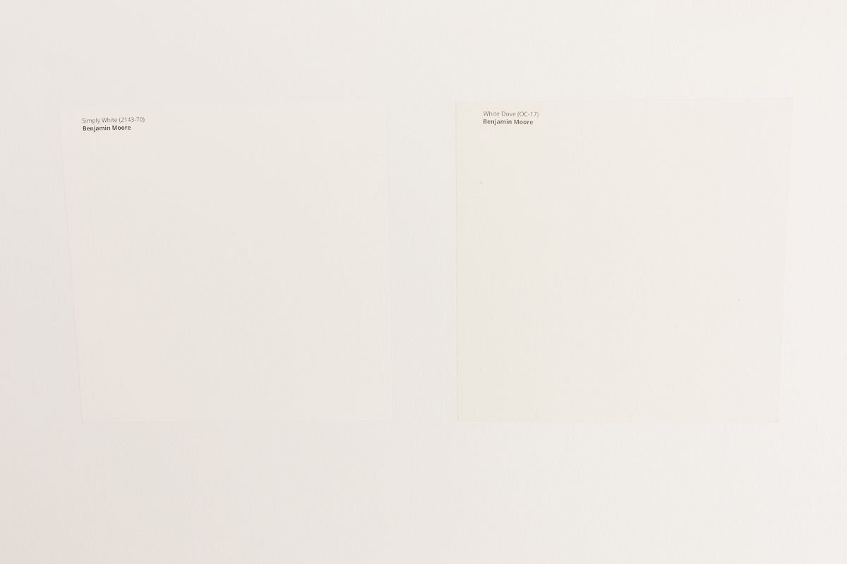 两个白色采样涂料样品卡在白色的墙壁上