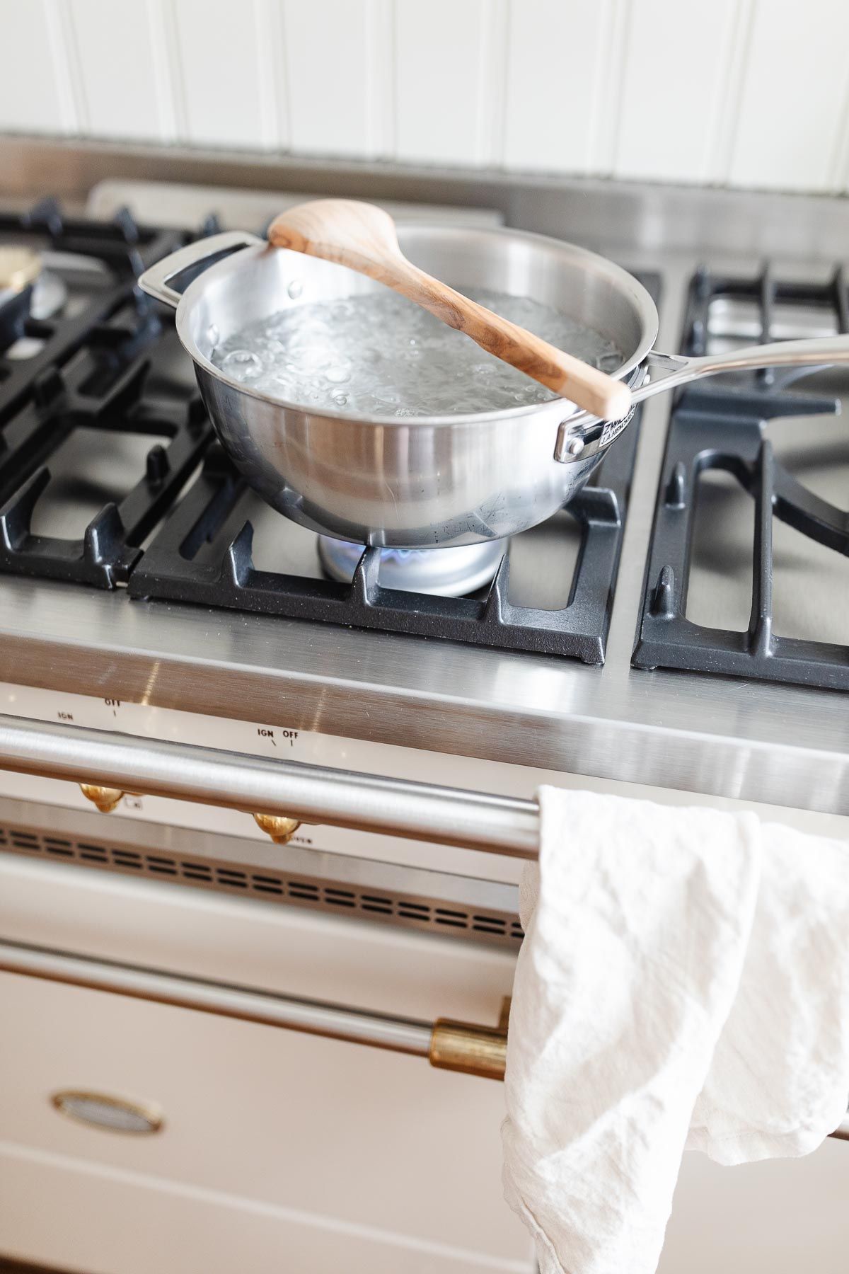 一块银锅在法国范围内，将木勺放在顶部，以阻止水沸腾。