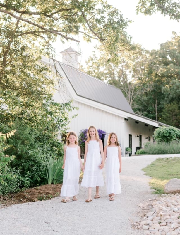 三个穿着白色礼服的小女孩在白色教堂前