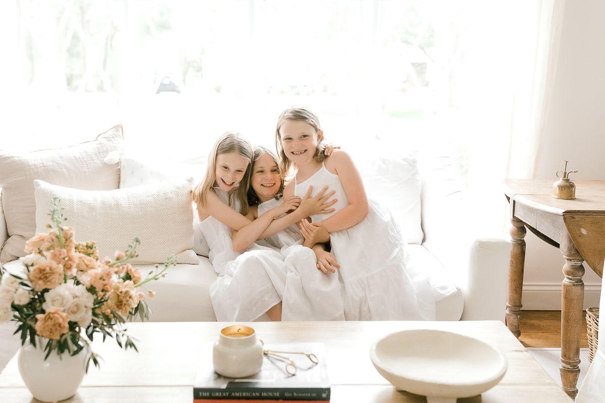 白色礼服的三个小女孩在白色沙发
