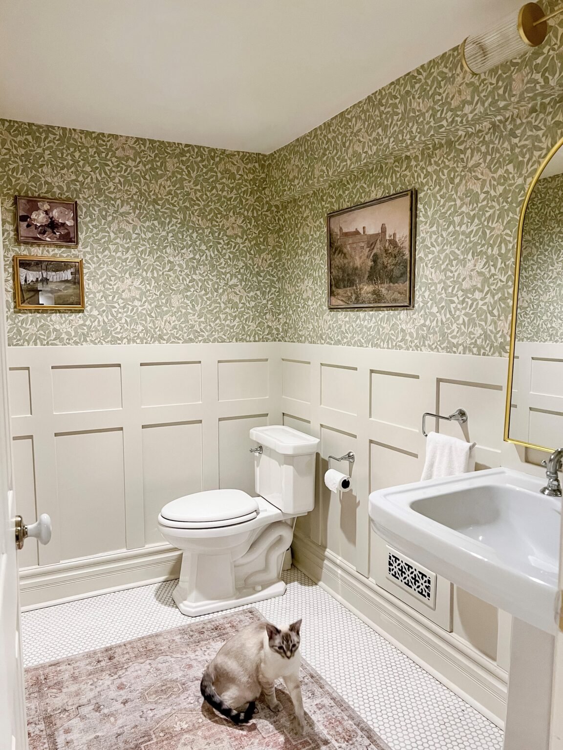 浴室贴着墙纸，墙底有木板和木条，用本杰明·摩尔(Benjamin Moore)的天然奶油绘制。