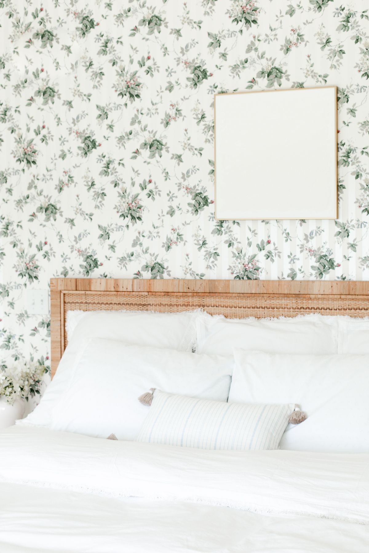 卧室贴着墙纸，床上方挂着白色的纹理墙画