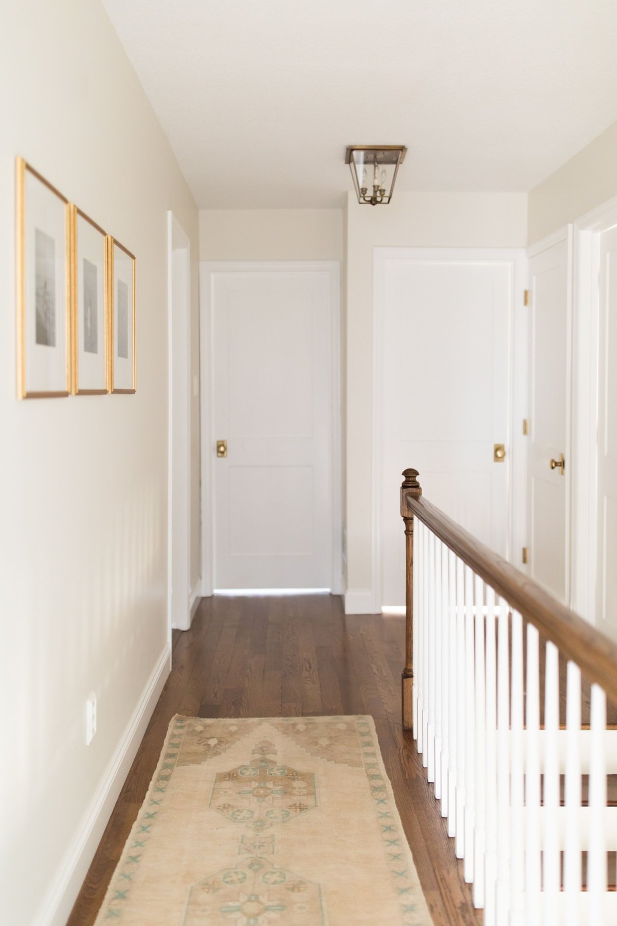 一个白色的走廊，上面有传统的地毯在硬木地板上