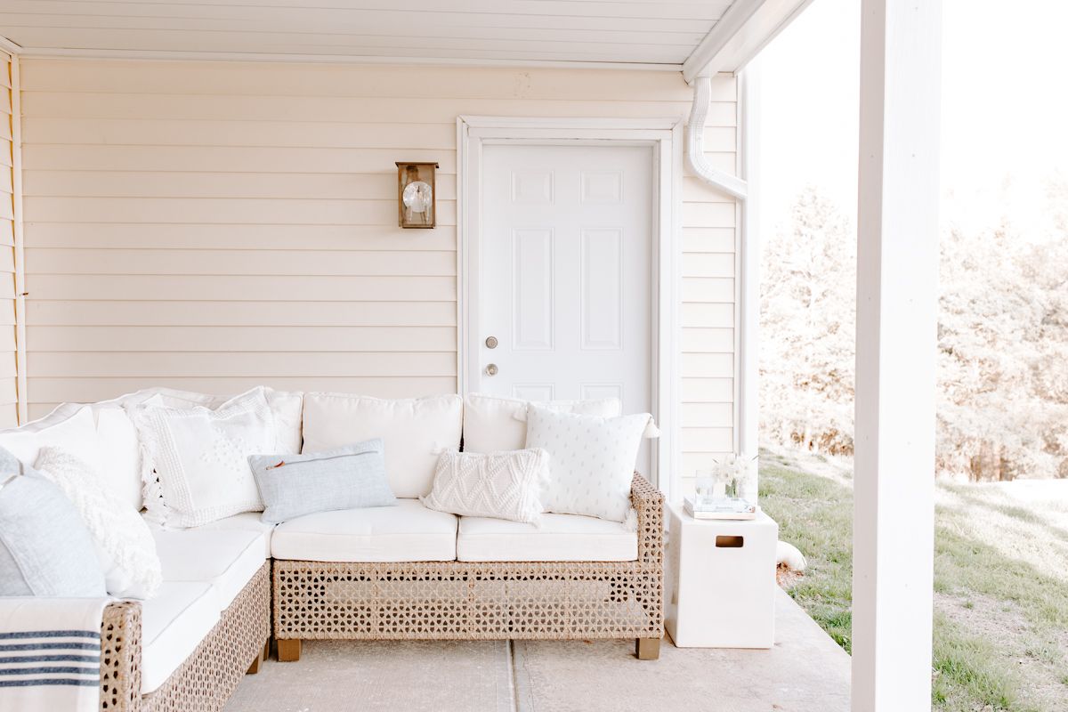 带有柳条部分和白色正方形陶瓷花园凳子的露台