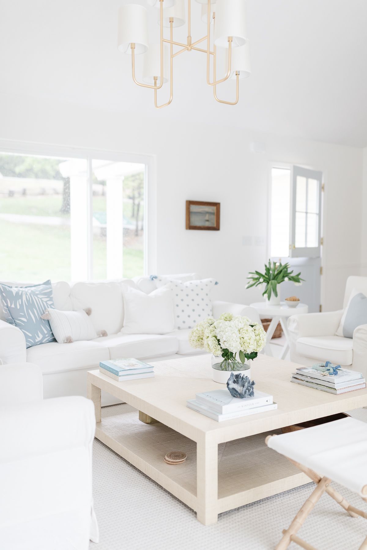 明亮的白色客厅里有白色的沙发和浅蓝色的枕头
