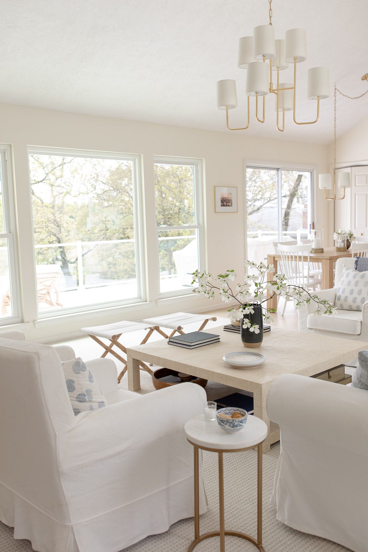 一个白色的客厅，在厨房里用黄铜高架照明设计在厨房里吃饭