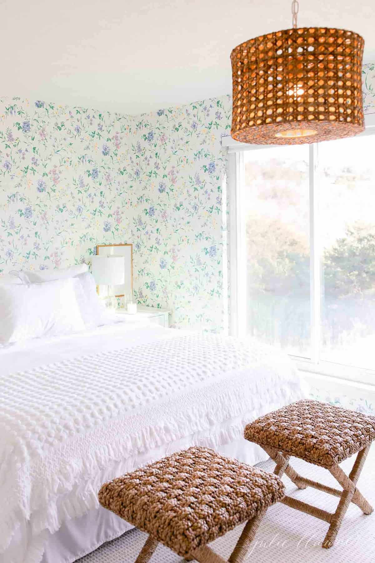 一间带有木制装饰的白色卧室和一张陈述花卉墙纸。