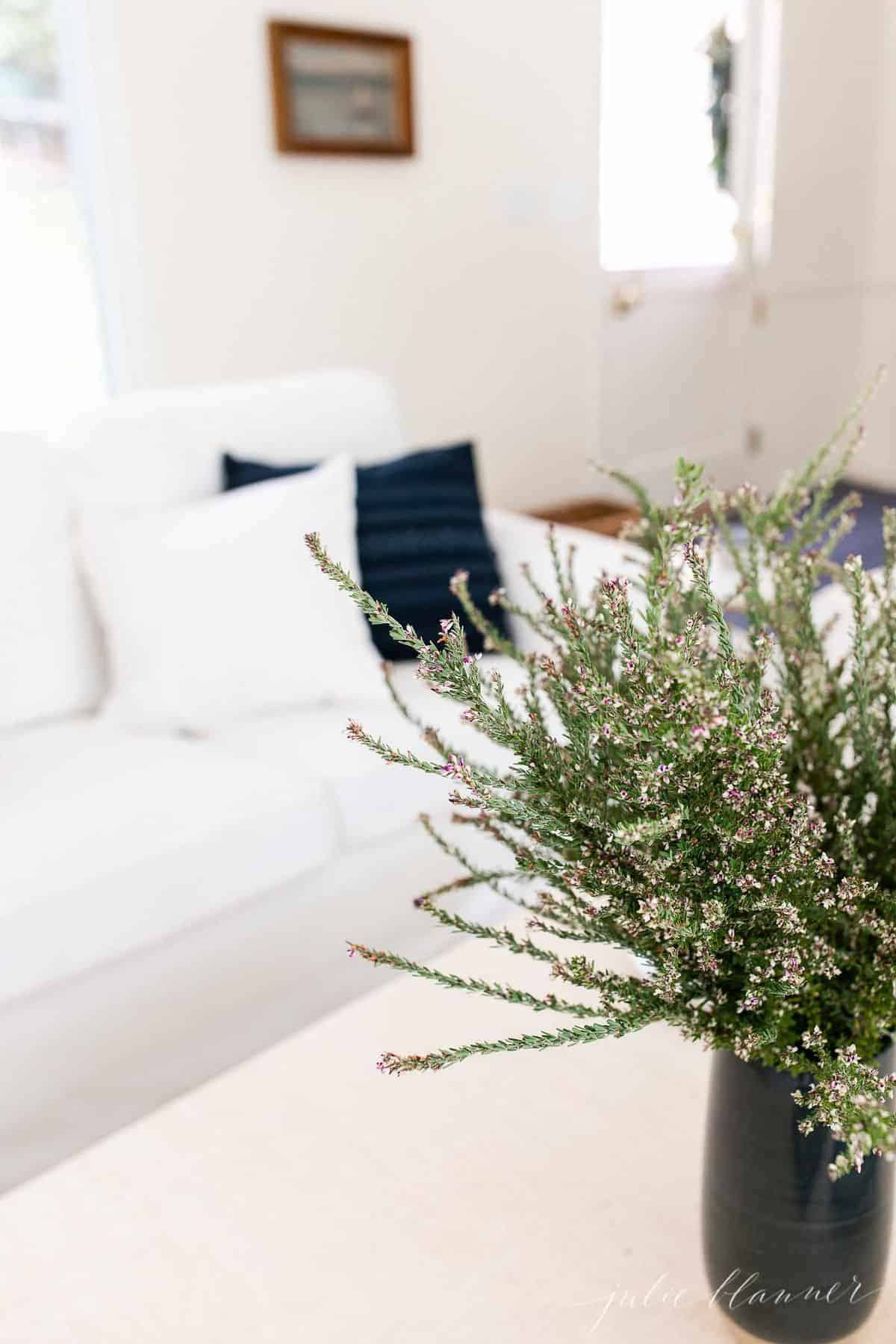 白色的客厅，海军蓝的枕头，海军蓝的花瓶，满是秋天的野花。