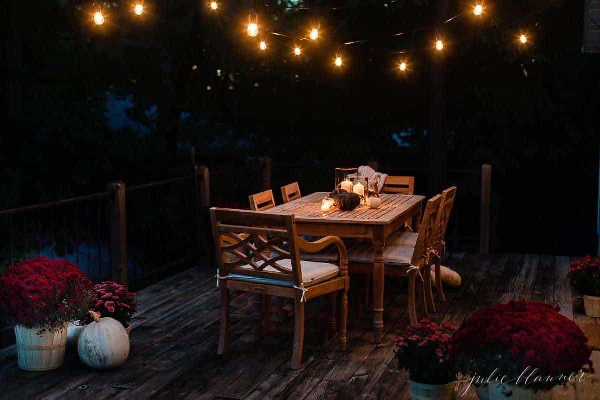 一个为秋天装饰的甲板餐厅，用串灯、南瓜和菊花装饰