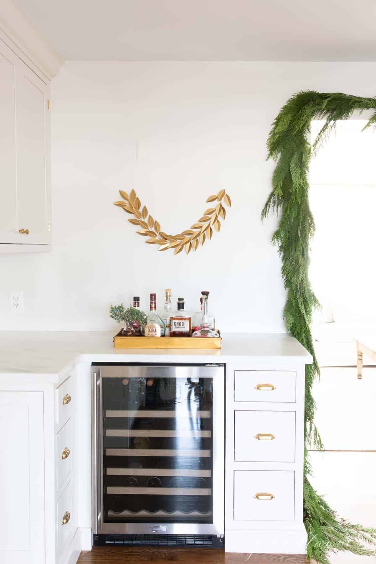 厨房里有嵌入式橱柜和葡萄酒冰箱，挂着圣诞绿色植物。