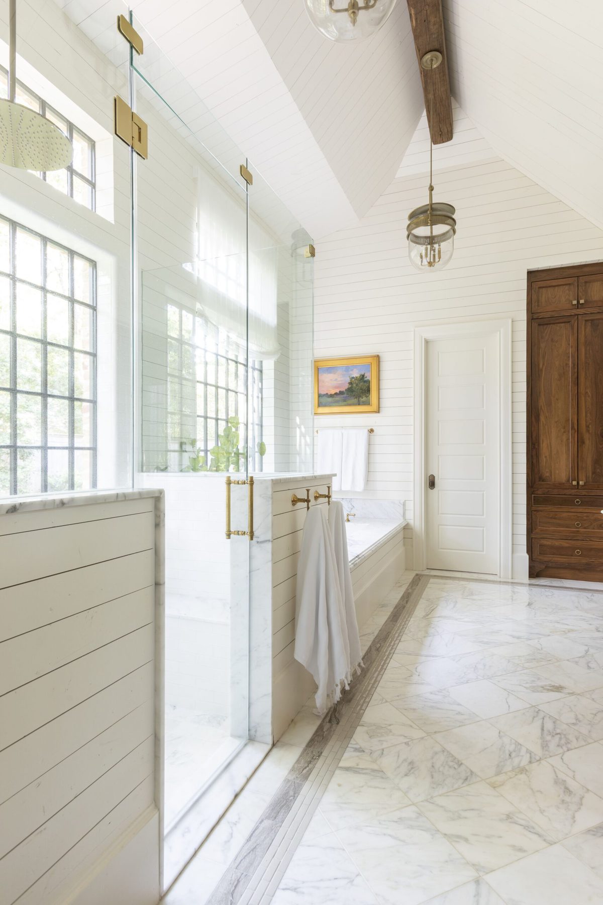 一间主要的浴室，带有云白色的墙壁和一扇木门